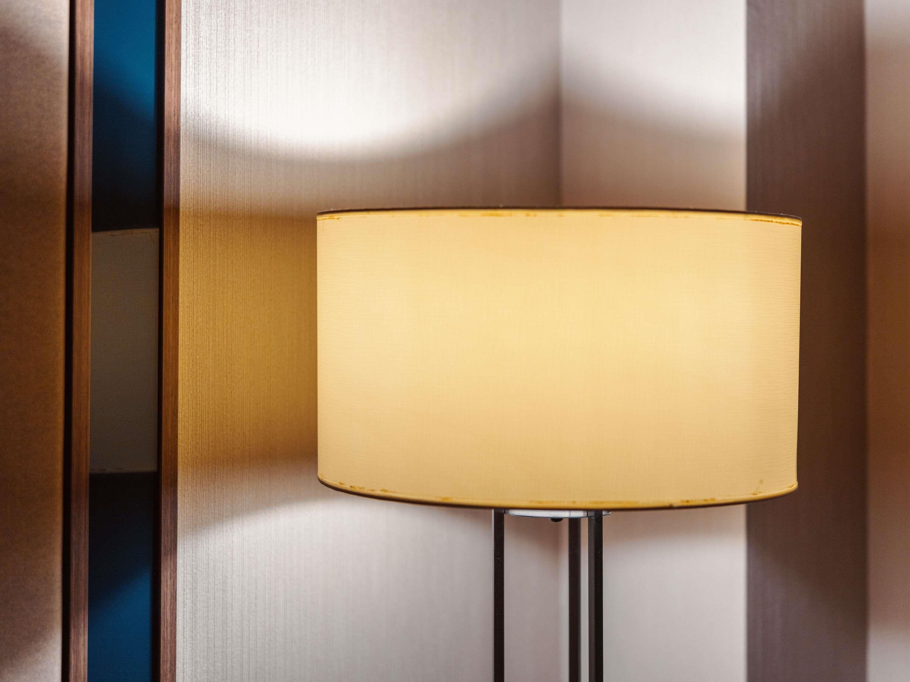 Une lampe murale dotée d’un abat-jour cylindrique.