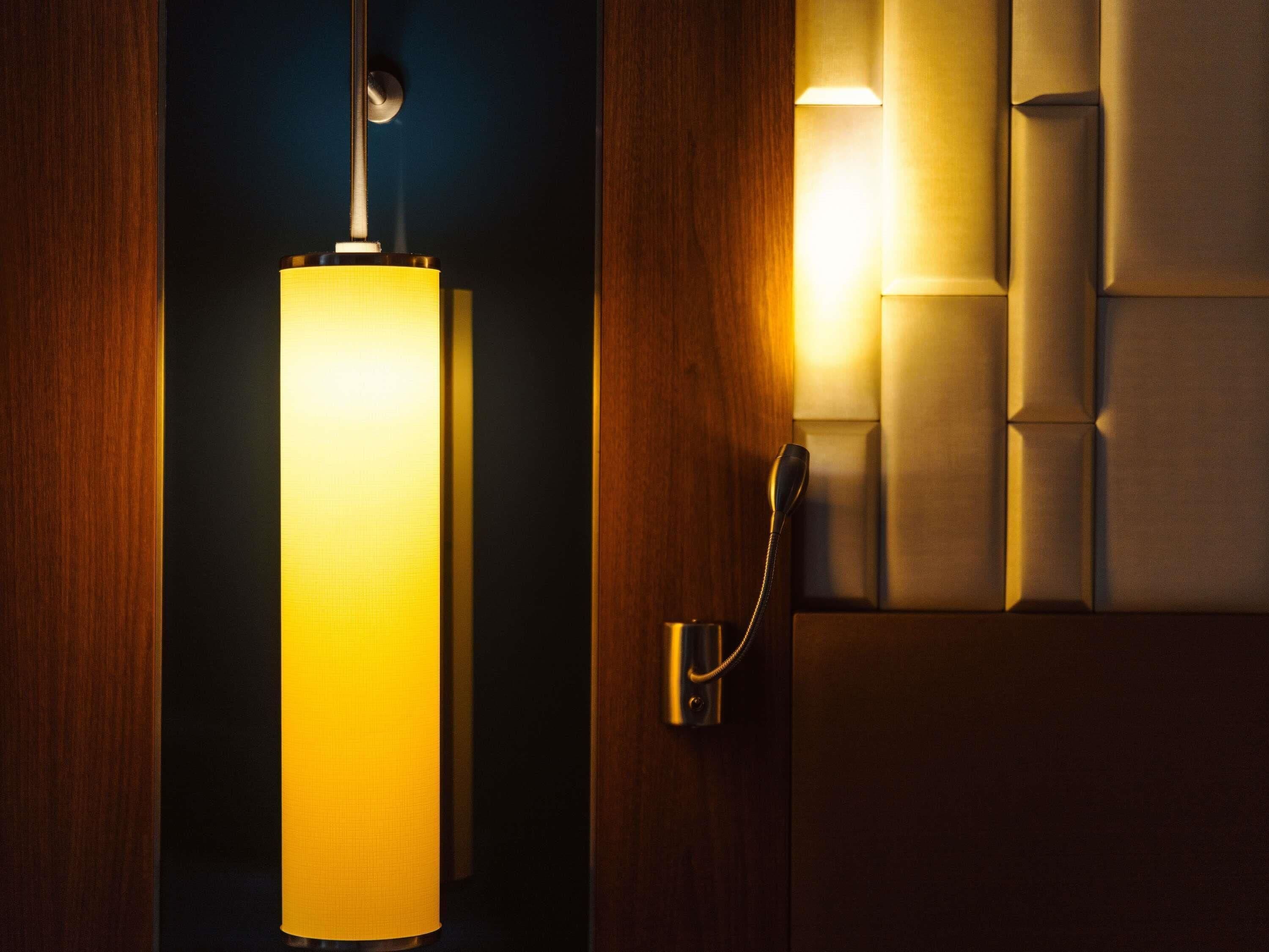 A room with a wall-mounted telephone and a hanging light fixture.
