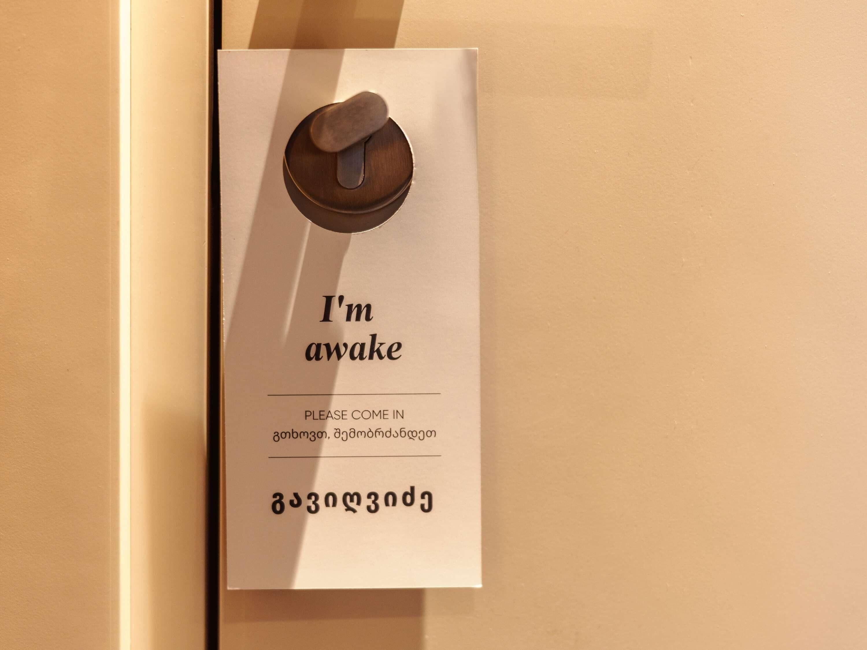 Een deurplaatje met een sleutelgat en tekst die aangeeft dat de kamer beschikbaar is.