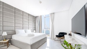 Camera d'albergo moderna con un grande letto, una TV a schermo piatto, una scrivania e vista sulla Torre Eiffel.