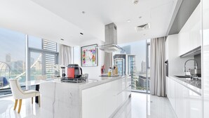 Una cucina moderna con isola in marmo, elettrodomestici in acciaio inossidabile e vista sulla città.