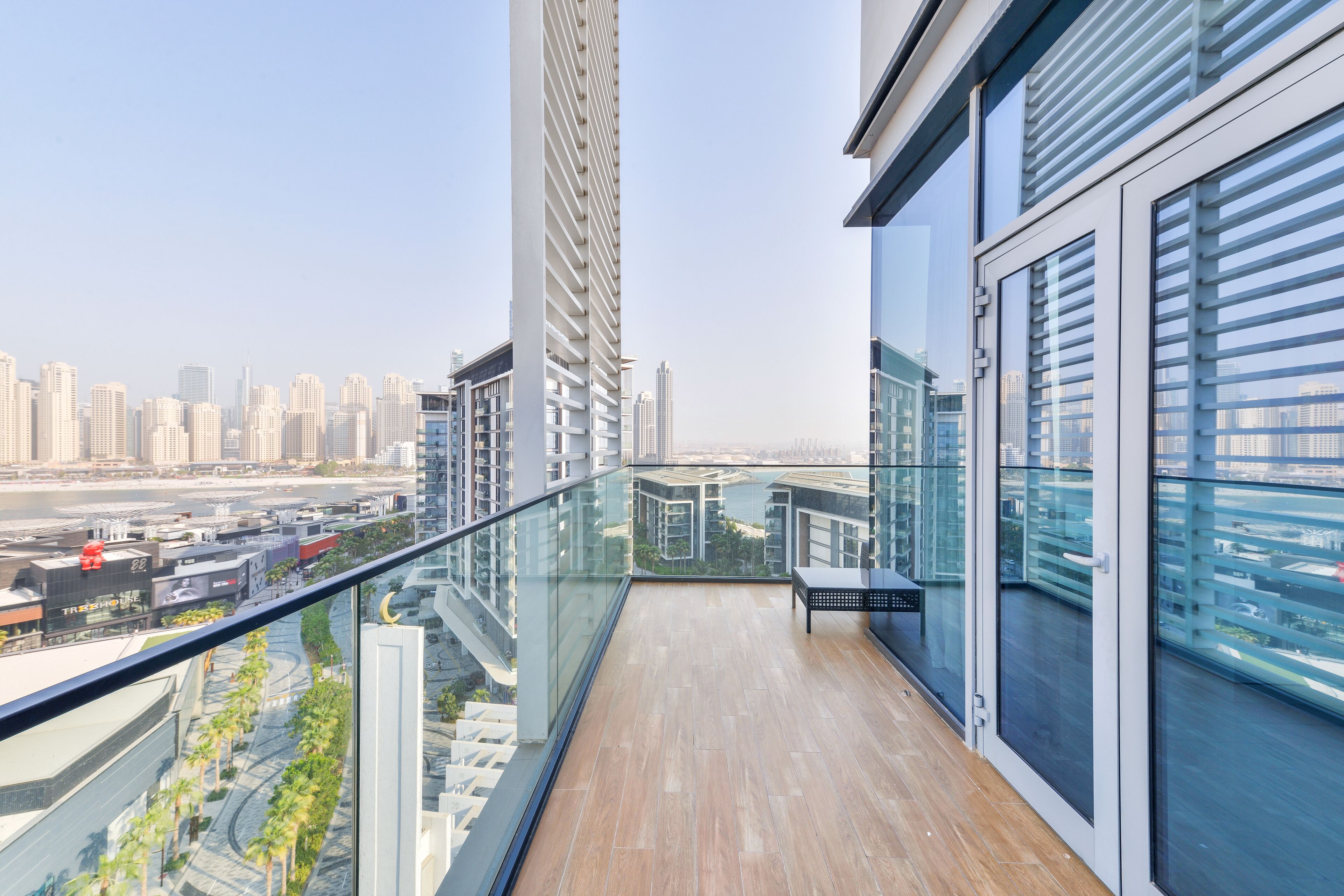 A balcony with a view of a cityscape, including tall buildings and a body of water.