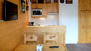 Un intérieur en bois comprenant un coin cuisine équipé d’un four à micro-ondes, d’une cuisinière et d’un évier.