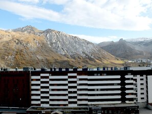Un bâtiment moderne à la façade noire et blanche distinctive, qui se détache sur un paysage montagneux.