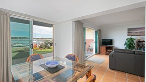 Una sala moderna con una mesa de vidrio, un sofá y un televisor.