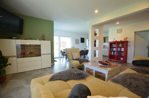 A modern living room with a sofa, coffee table, and a bookshelf.