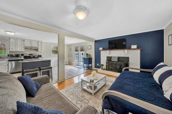 Bright and cozy living room with a fireplace, open to the kitchen, perfect for relaxing together