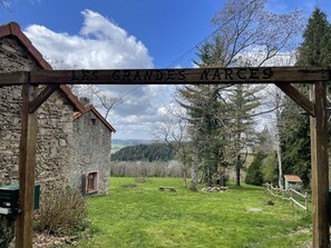 A rustic stone building with a wooden sign reading "LES GRANDES NARCES". - Green haven for couples with parking (Châtel-Montagne)