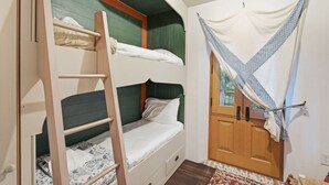 A bunk bed with a ladder, a wooden wardrobe, and a window with curtains. - Incredible Coastal Castle on Sullivans Island (Sullivans Island)