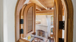 An arched doorway leading to a cozy interior with a fireplace, seating area, and a view of a church. - Incredible Coastal Castle on Sullivans Island (Sullivans Island)