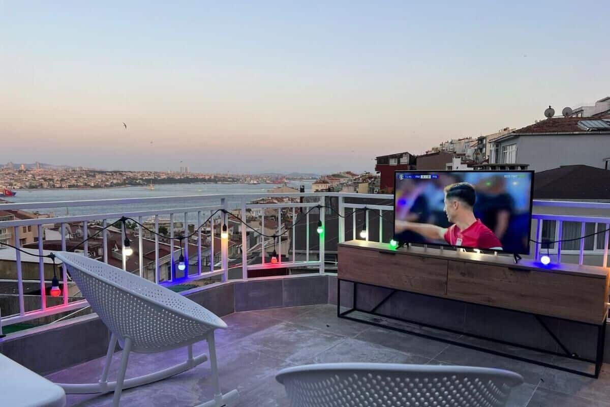 A terrace with a TV, seating, and a view of the city.