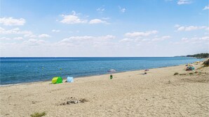 A beach with tents and umbrellas, a clear sky, and calm water. - Awesome apartment in Sta Maria Poggio with WiFi (Sta Maria Poggio)