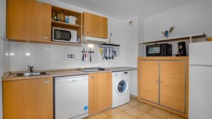 A compact kitchen with a dishwasher, washing machine, microwave, and a small refrigerator. - Awesome apartment in Sta Maria Poggio with WiFi (Sta Maria Poggio)