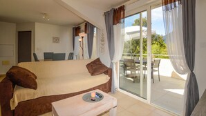 A cozy room with a bed, a small table, and a balcony with outdoor furniture. - Awesome apartment in Sta Maria Poggio with WiFi (Sta Maria Poggio)