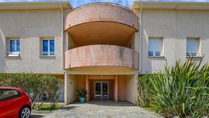 A two-story building with a central balcony, a gated entrance, and potted plants. - Awesome apartment in Sta Maria Poggio with WiFi (Sta Maria Poggio)