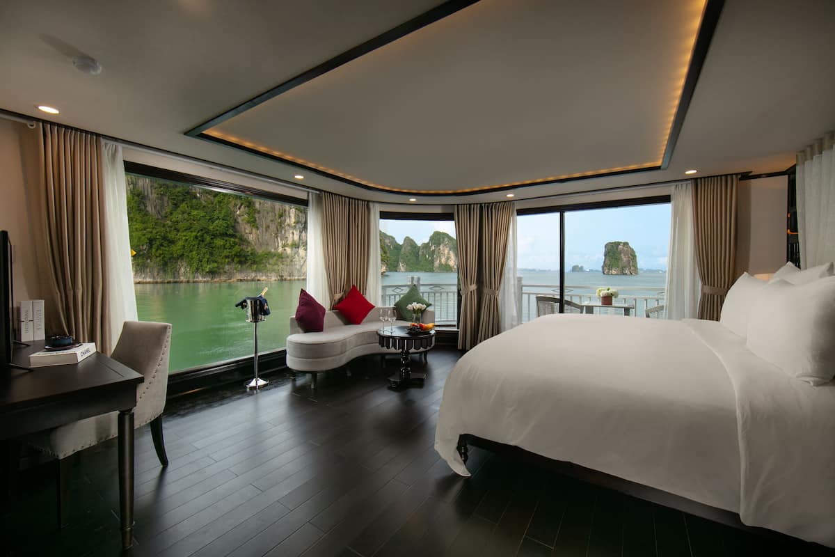 Una habitación de hotel moderna con una cama grande, un escritorio y vista al mar.