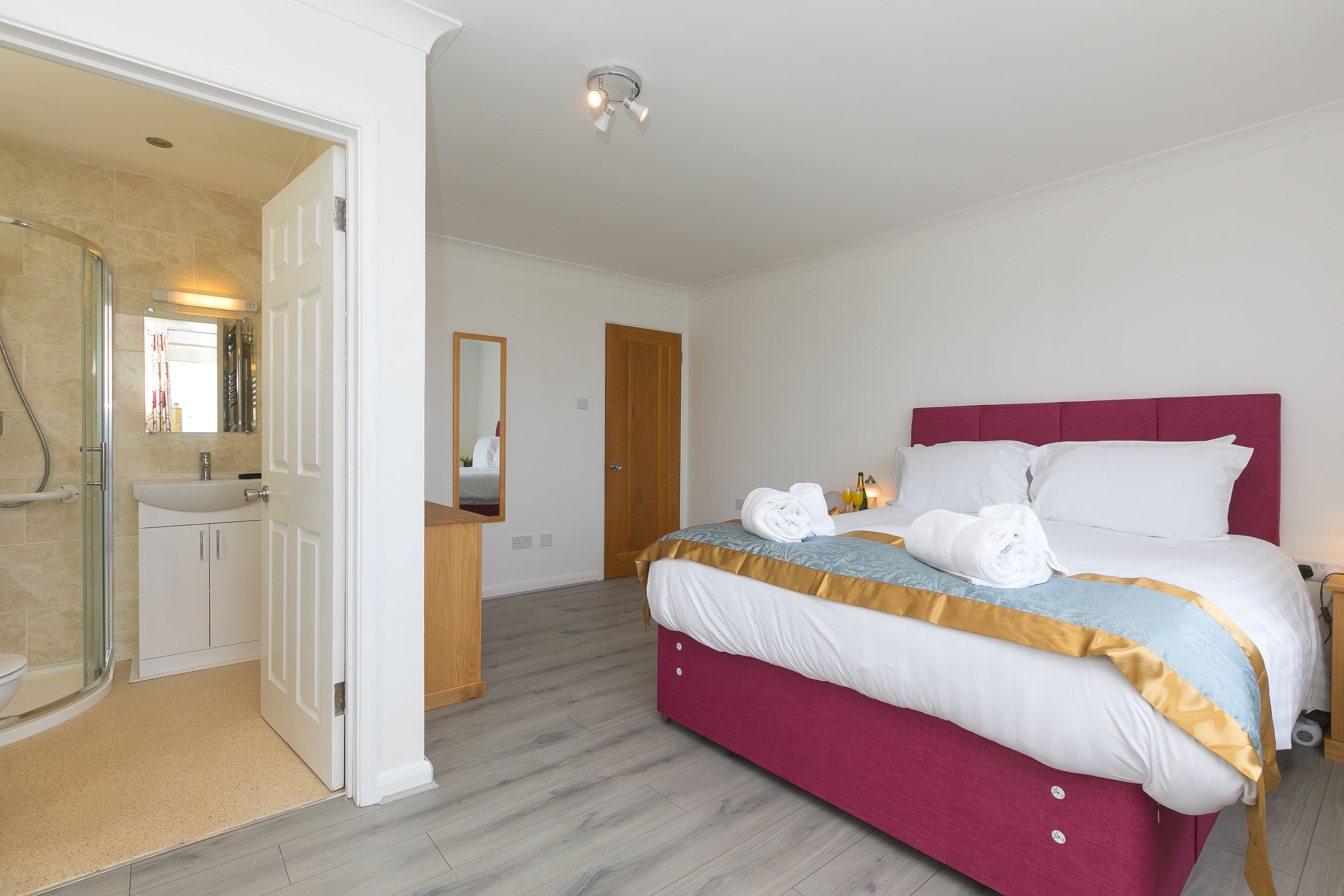 Een hotelkamer met een bed, een badkamer en een douche.