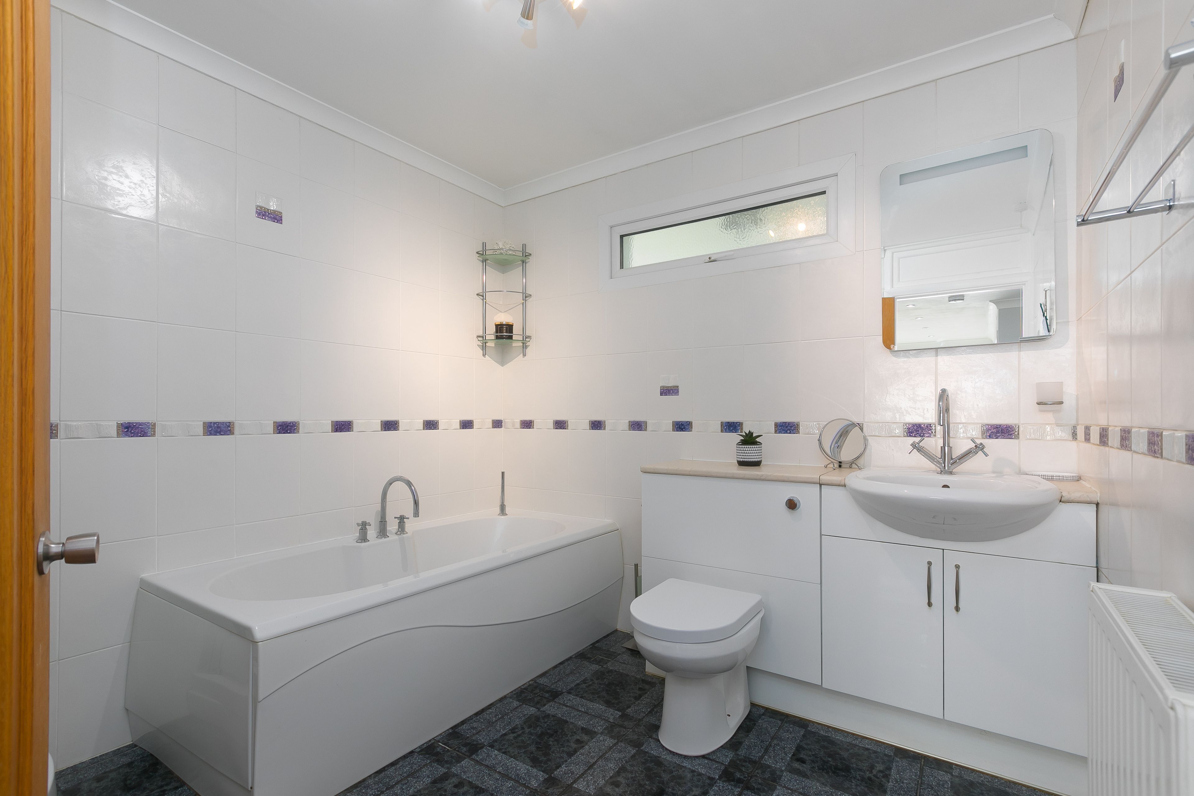 A modern bathroom with a bathtub, toilet, and sink.
