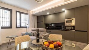 A modern apartment with a dining area, kitchen, and living room.