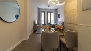 Een moderne hotelkamer met een zithoek, een comfortabele zithoek, een grote spiegel en een bijzondere lamp.