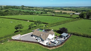 A large house with a spacious front yard, surrounded by lush green fields and a few scattered trees. - Ashlea (Launceston)