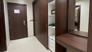 Quarto com guarda-roupa, espelho e chão coberto por azulejos brancos.