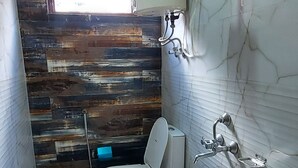 Un baño con inodoro, lavabo y zona de ducha.