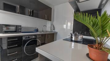 Een koelkast/vriezer, een magnetron, een oven, een kookplaat