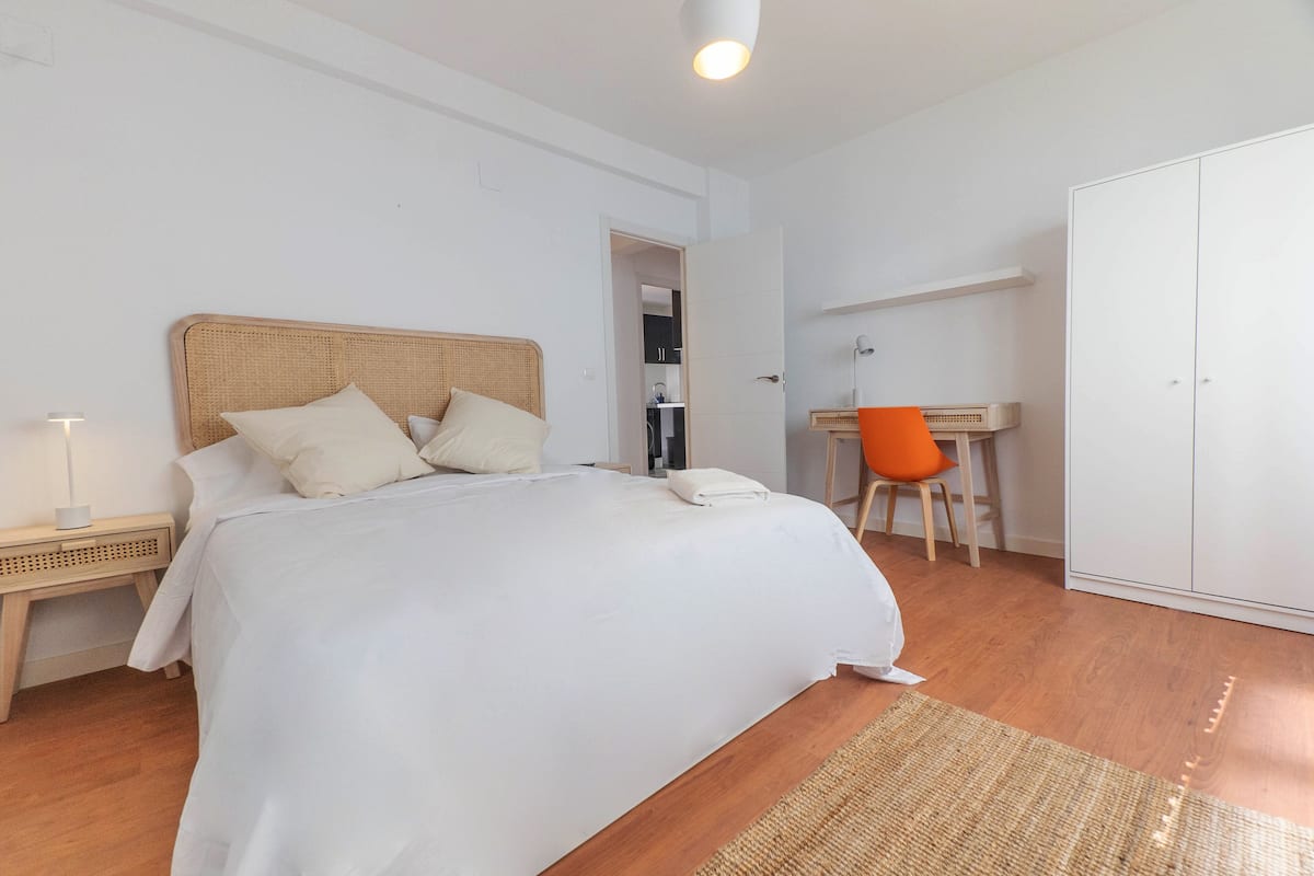 Ein Schlafzimmer mit Bett, Schreibtisch und Kleiderschrank.