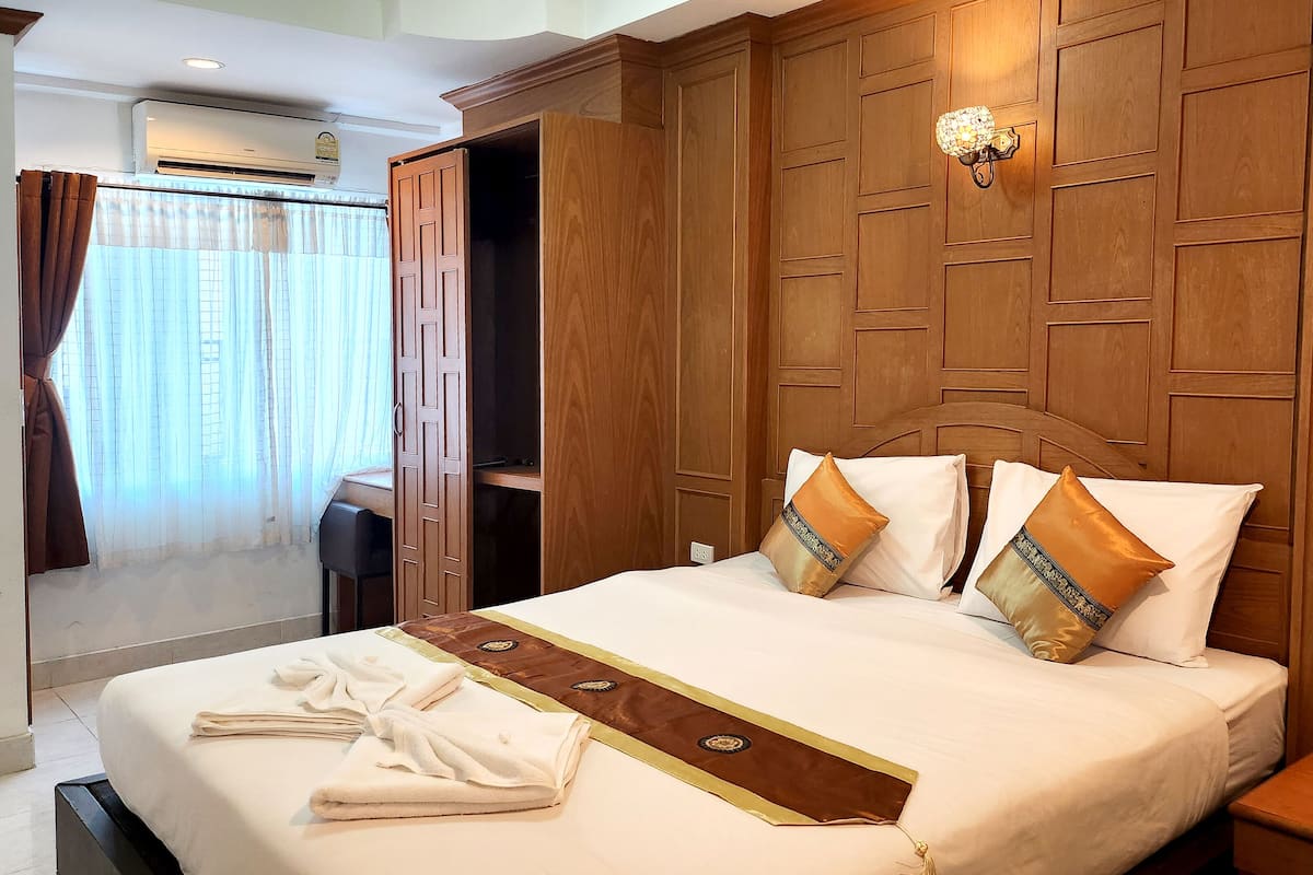 Ein Hotelzimmer mit einem großen Bett, einem Holz-Kopfteil und einem Nachttisch.