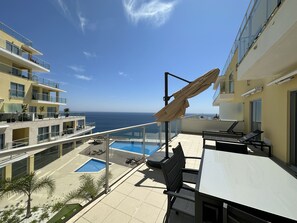 A rooftop terrace with a pool, lounge chairs, and a view of the ocean. - Comfort & Style with best sea view  (Sesimbra)