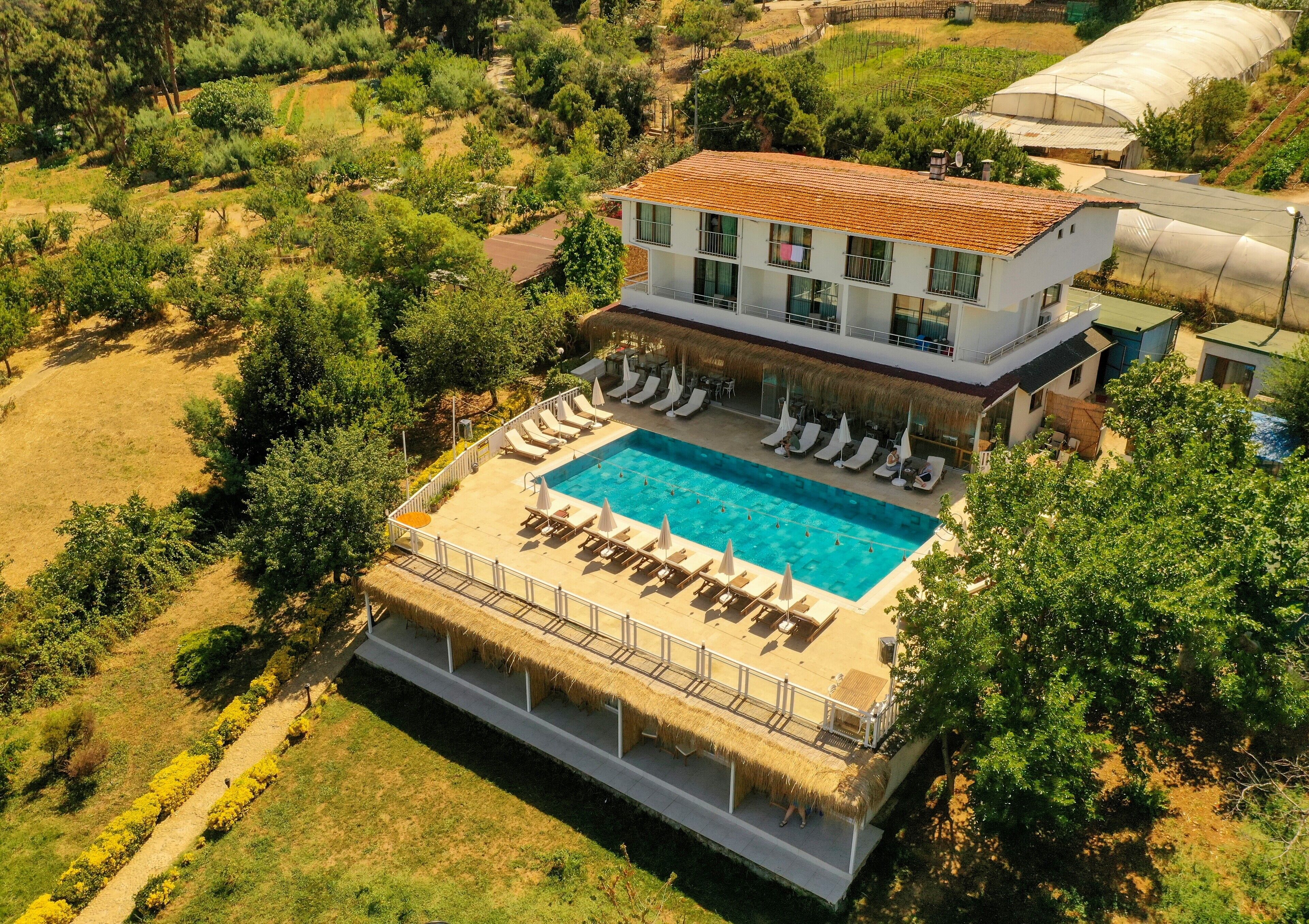 A modern two-story building with a swimming pool and outdoor seating area.