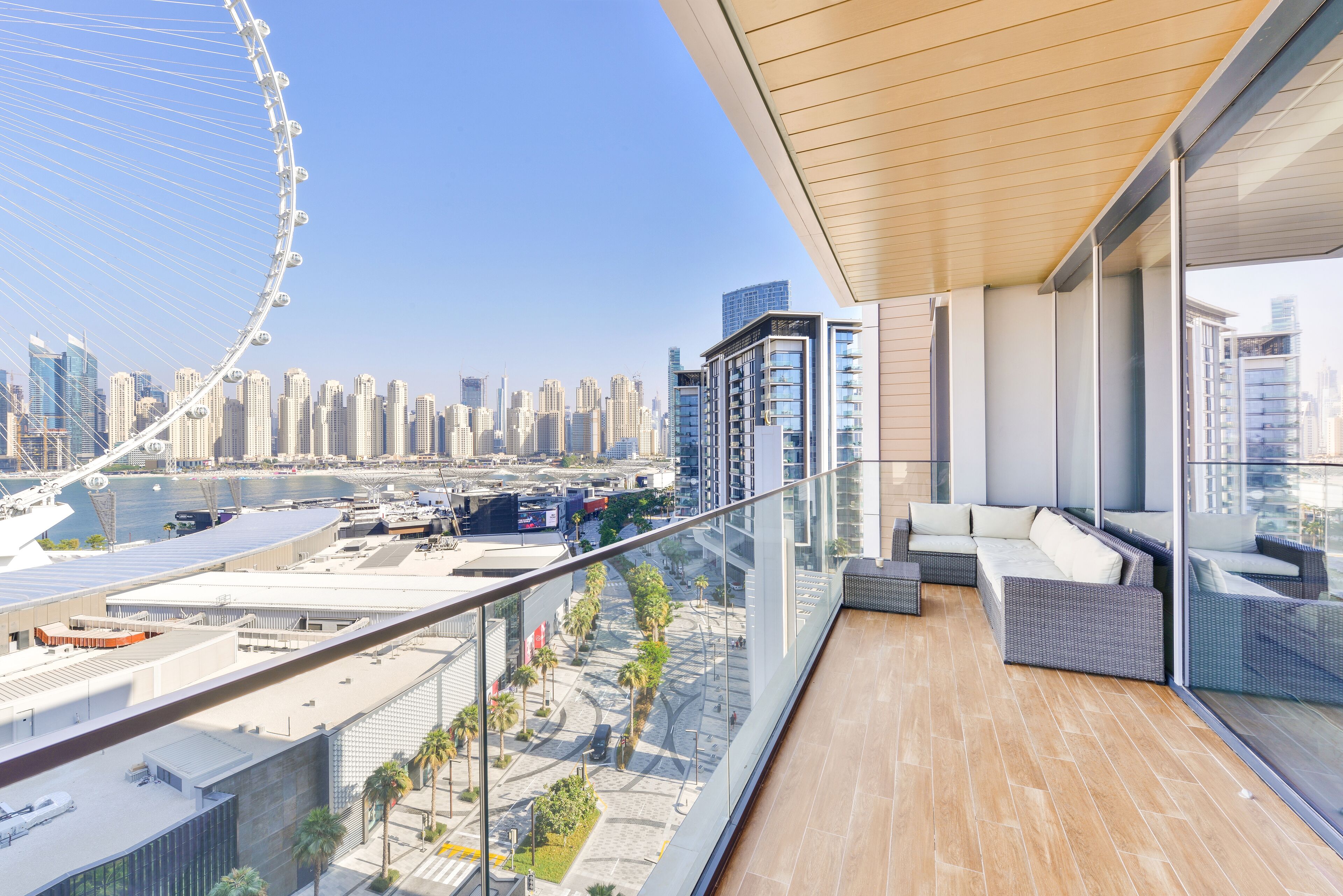 A balcony with a view of a cityscape, including a Ferris wheel and modern buildings.