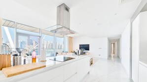 Eine moderne Küche mit einer großen Kochinsel, Blick auf die Stadt und einem eleganten Design.