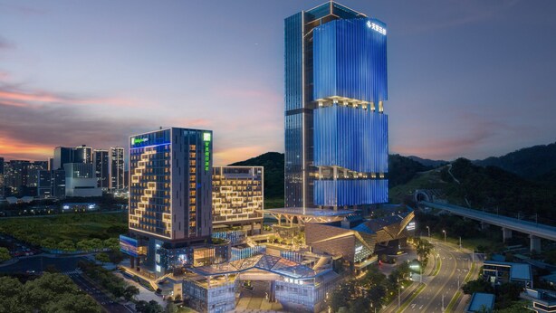 A modern hotel complex with multiple buildings, a central atrium, and a surrounding landscaped area. - Holiday Inn Express Shenzhen Guangming Cloud Park by IHG (Shenzhen)