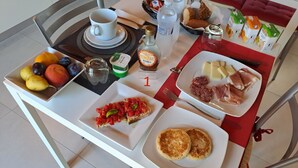 Une table de petit-déjeuner avec une variété d’aliments, notamment des toasts, des fruits, du fromage et des viennoiseries.