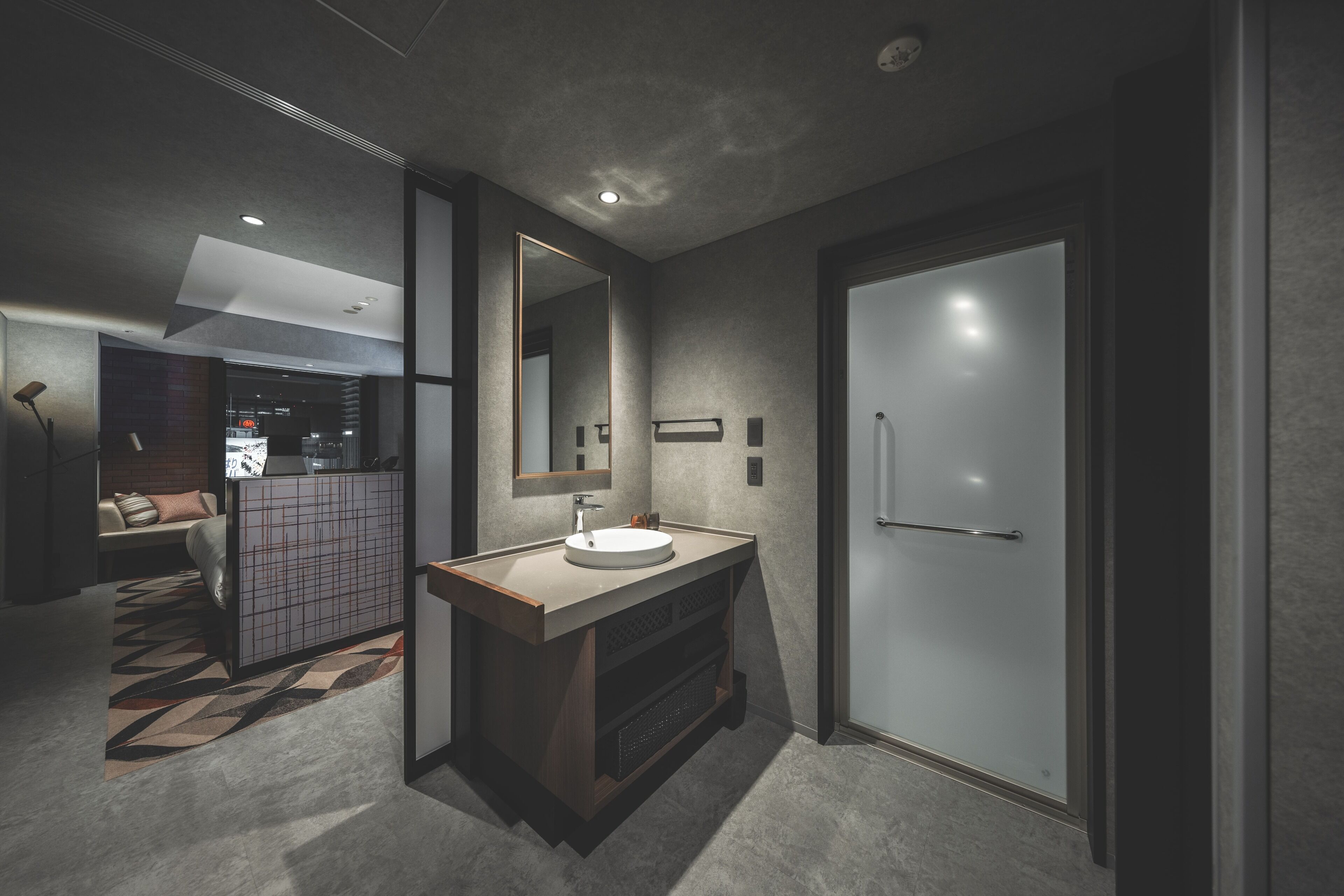 A modern bathroom with a large mirror, a sink, and a door.