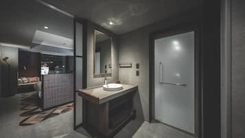 A modern bathroom with a large mirror, a sink, and a door.