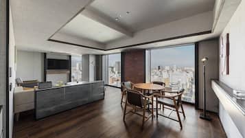 A modern living room with a dining area, large windows, and a city view.