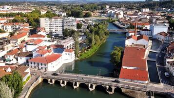Un río con un puente que lo cruza, rodeado de edificios con tejados rojos.