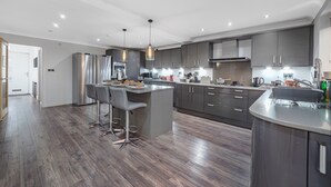 A modern kitchen with a central island, stainless steel appliances, and pendant lighting. - Rainfall Shower | Pool/Snooker | x 4 Cars (Berkshire)