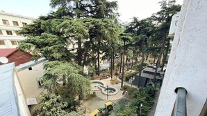 Un patio con árboles, una zona de estar circular y un parque infantil.