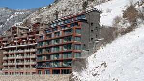 Un hotel de varios pisos con un diseño moderno, que cuenta con balcones y grandes ventanales.