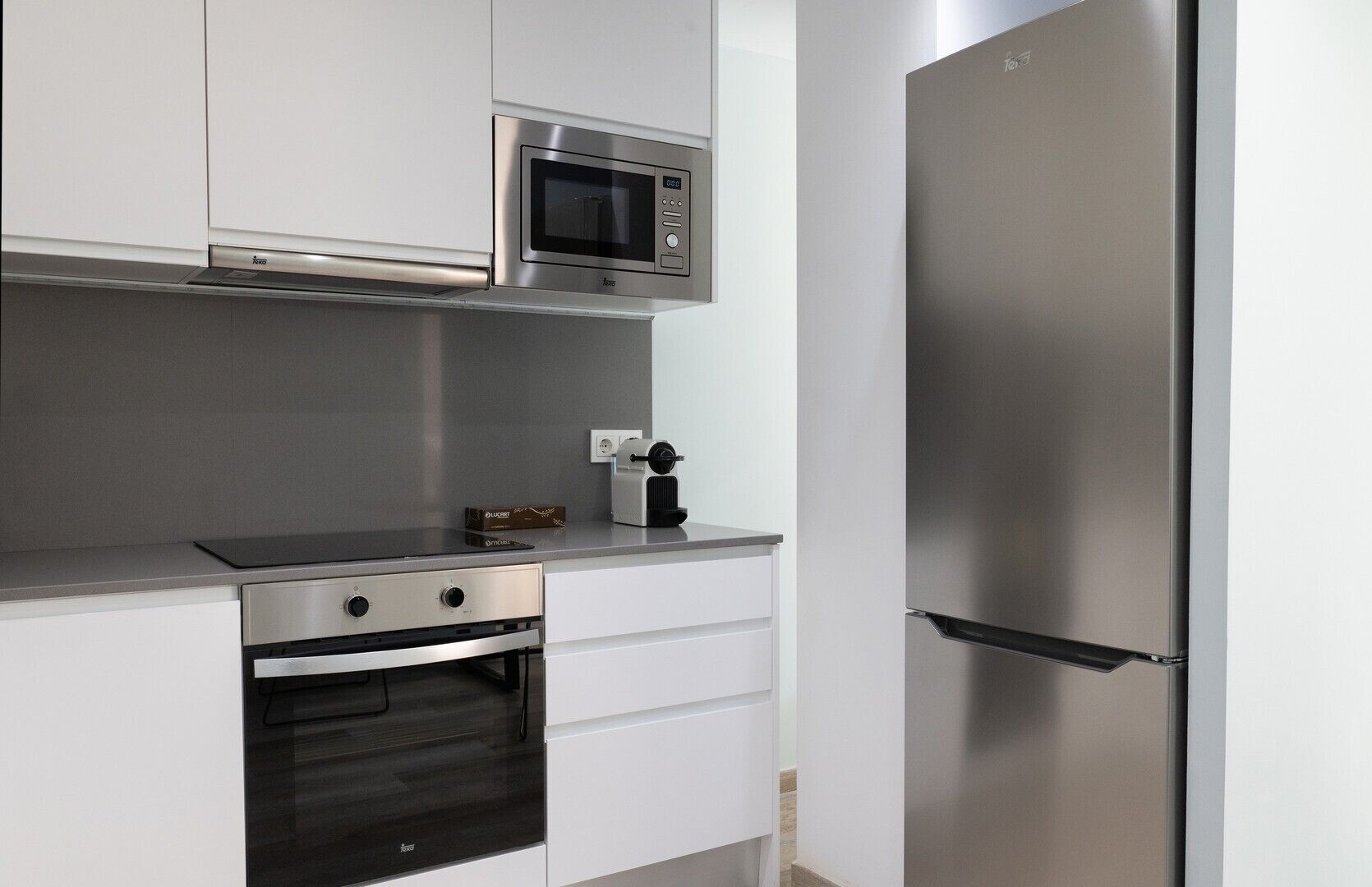 A modern kitchen with stainless steel appliances, including a microwave, oven, and refrigerator.