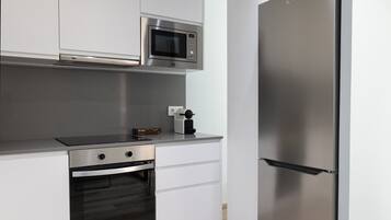 A modern kitchen with stainless steel appliances, including a microwave, oven, and refrigerator.