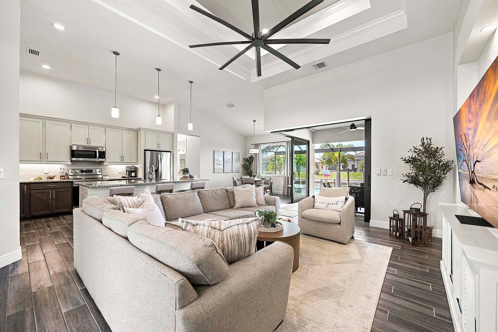 A modern living room with a sectional sofa, a coffee table, and a dining area with chairs.