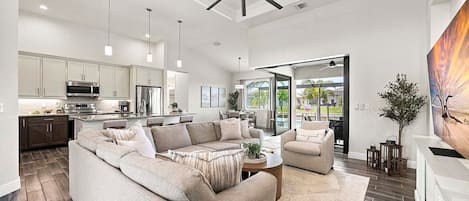 A modern living room with a sectional sofa, a coffee table, and a dining area with chairs.