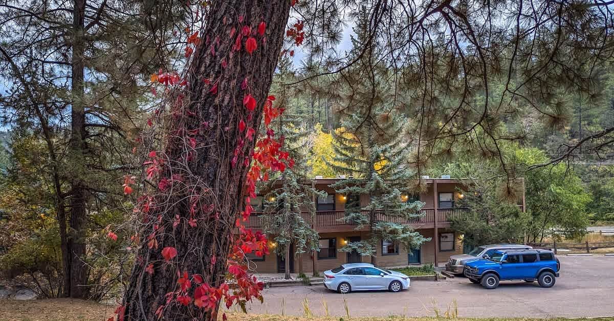 En byggnad med två våningar, en balkong på den övre våningen och en parkeringsplats med plats för två bilar.