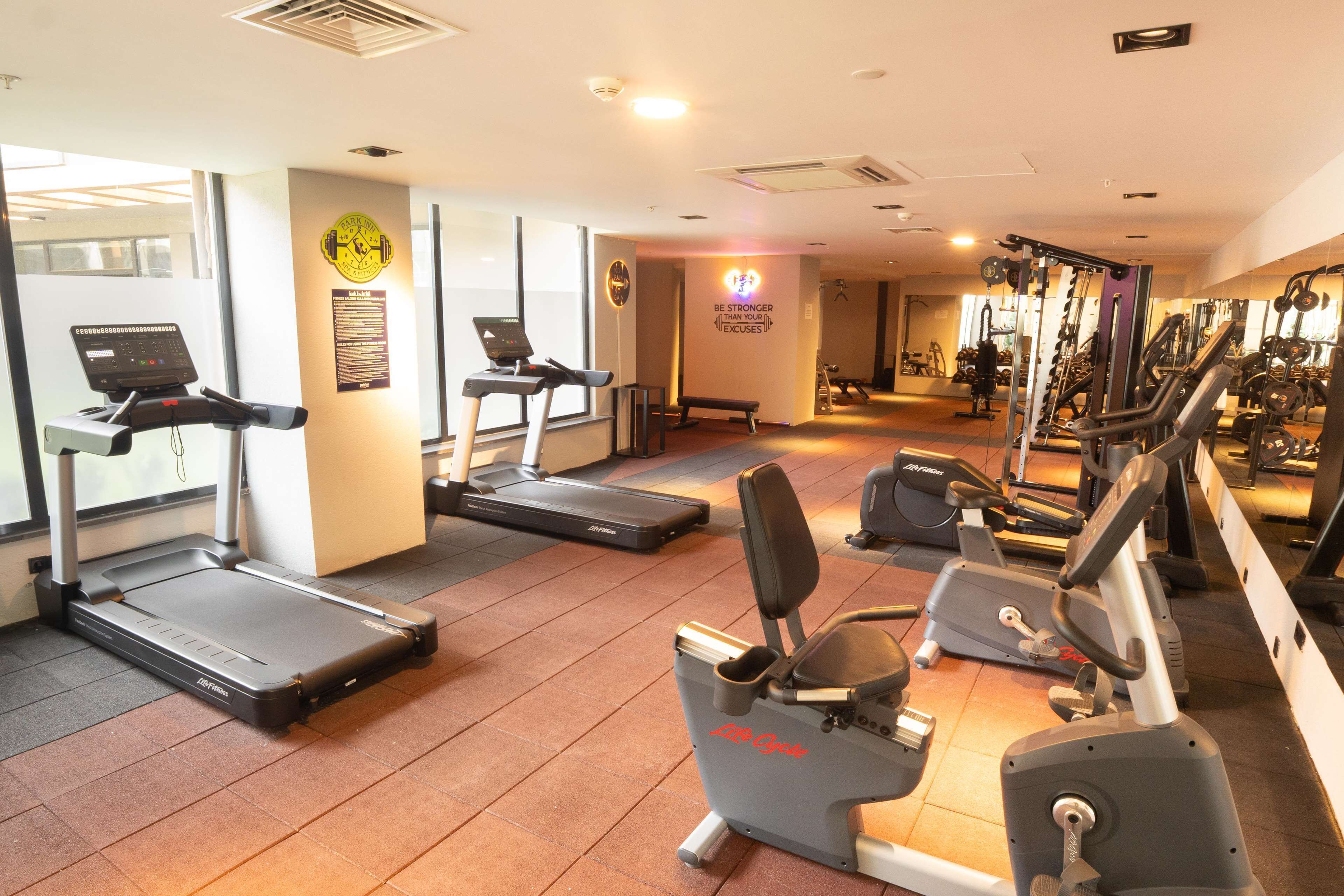 A gym with treadmills, elliptical machines, and weightlifting equipment.