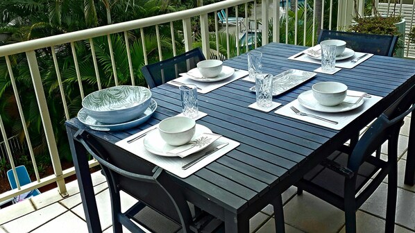 Enjoy meals in a serene outdoor setting with a beautifully set table for four.